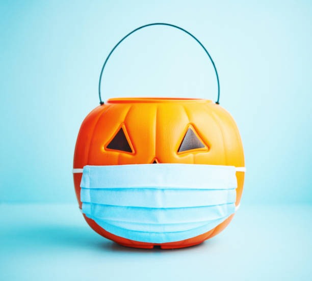 istock Halloween background with Jack O'Lantern bucket wearing face mask 1275748383