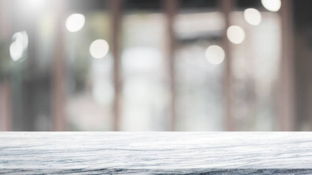 istock Empty white marble stone table top and blur glass window interior cafe and restaurant banner mock up abstract background - can used for display or montage your products. 1275748413