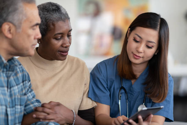 istock Visiting nurse consults with elderly couple 1275749206