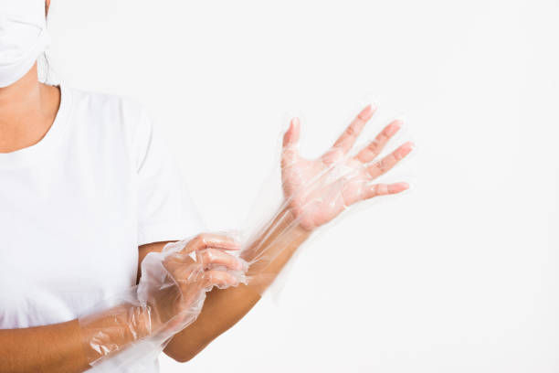 istock Woman hand wearing single use protect disposable transparent plastic glove 1275753033
