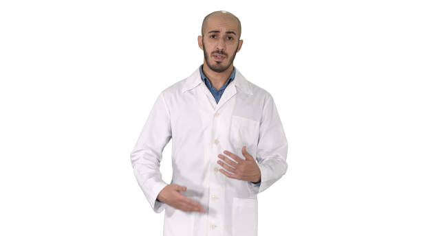 istock Friendly male doctor walking and talking looking in camera on white background 1275753571