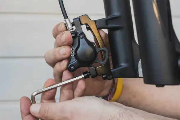 Photo of Tightening or removing disc brake caliper on a mountain bike.