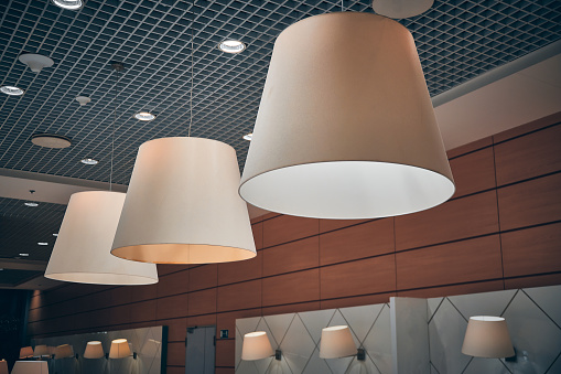 Lamps in conical shades in cafe at airport.