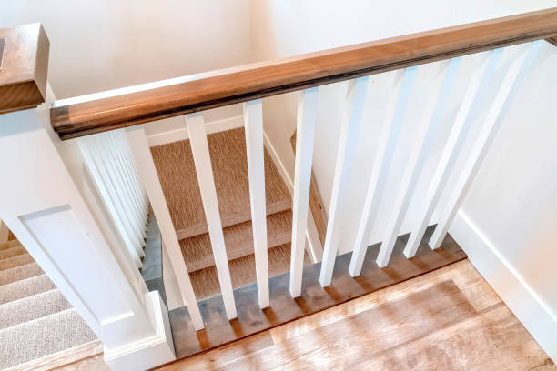 istock Looking down on U shaped indoor staircase with white baluster and brown handrail 1275755450
