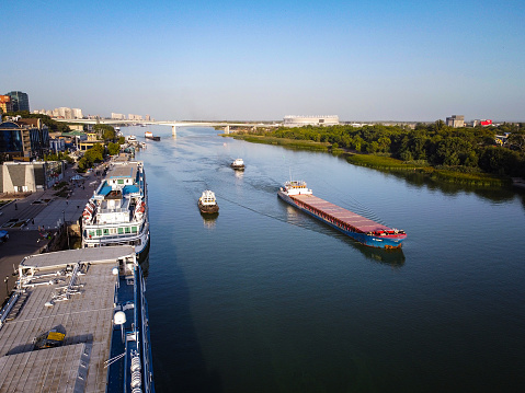 barge and boats float on the river and panorama of city at sunset aerial view.