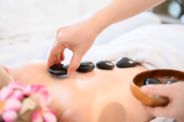 spa hot stone thai massage beauty treatment.young woman getting black hot stone on back her in spa salon - thai ethnicity massaging thailand thai culture imagens e fotografias de stock