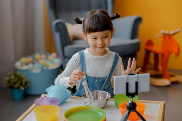 istock Cute Little Asian Kid doing online broadcasting 1275766450