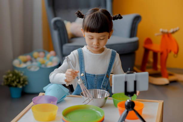 istock Cute Little Asian Kid doing online broadcasting 1275766460
