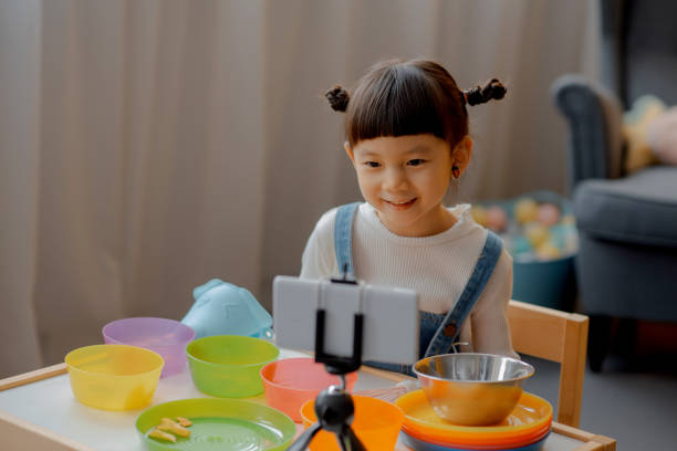 istock Cute Little Asian Kid doing online broadcasting 1275766492