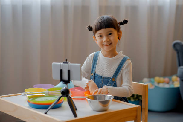 istock Cute Little Asian Kid doing online broadcasting 1275766496