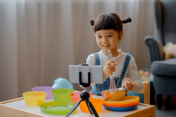 istock Cute Little Asian Kid doing online broadcasting 1275766497