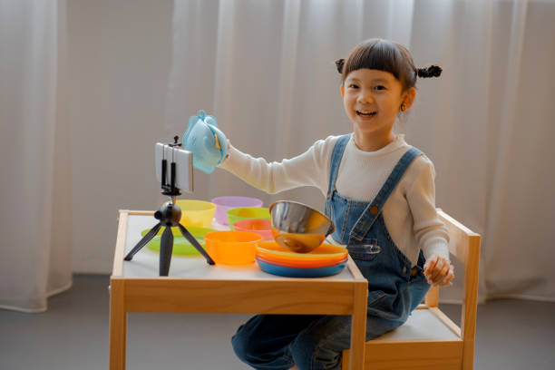 istock Cute Little Asian Kid doing online broadcasting 1275766499