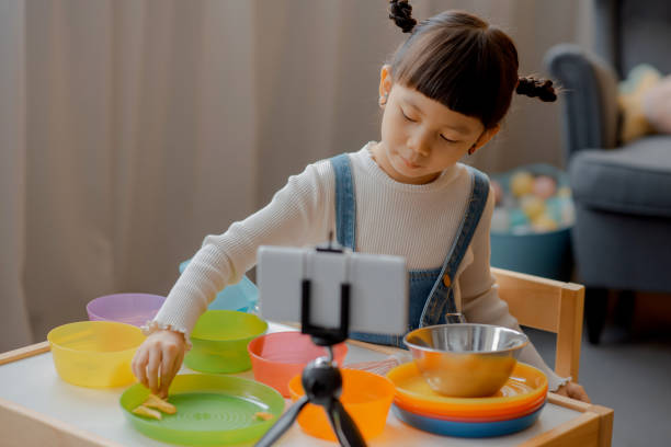 istock Cute Little Asian Kid doing online broadcasting 1275766504