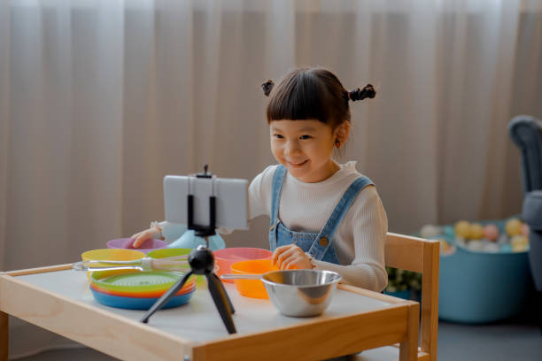 istock Cute Little Asian Kid doing online broadcasting 1275766506