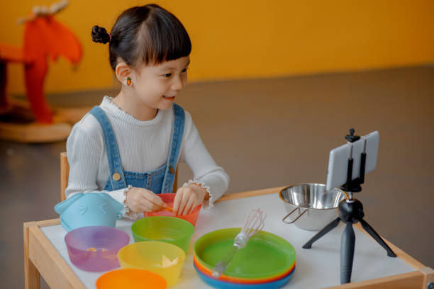 istock Cute Little Asian Kid doing online broadcasting 1275766508