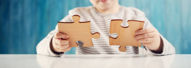 istock Little child holding puzzle pieces and trying to solve it 1275768297