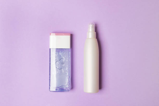 istock two cosmetic bottles on purple colored paper background 1275771323