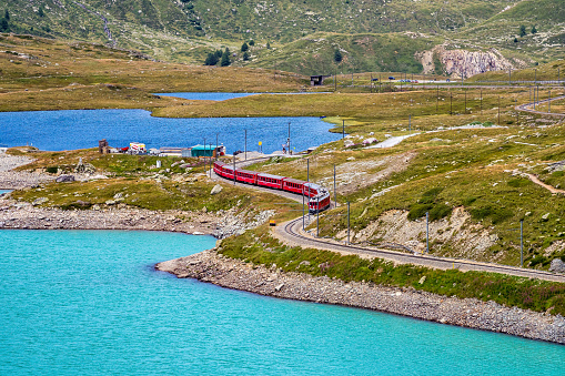 Bernina Express train at the White Lake in Ospizio Bernina, upper Engadin, Graubuenden, Grisons, Switzerland.