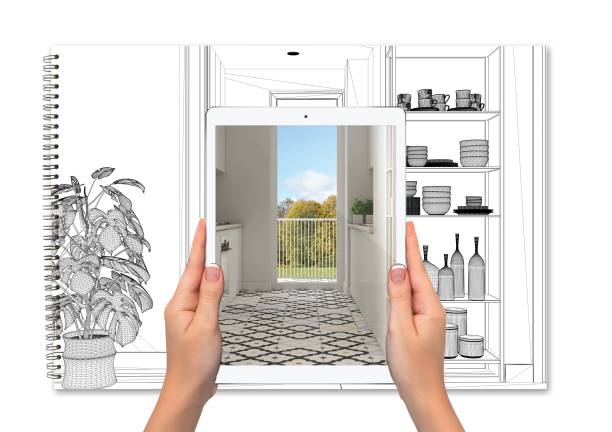 istock Hands holding tablet showing kitchen, notebook with blueprint sketch in the background, augmented reality concept, application to simulate furniture and interior design products 1275772504