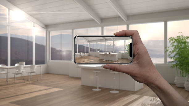 istock Hand holding smart phone, AR application, simulate furniture and interior design products in real home, architect designer concept, blur background, modern white and wooden kitchen 1275773055