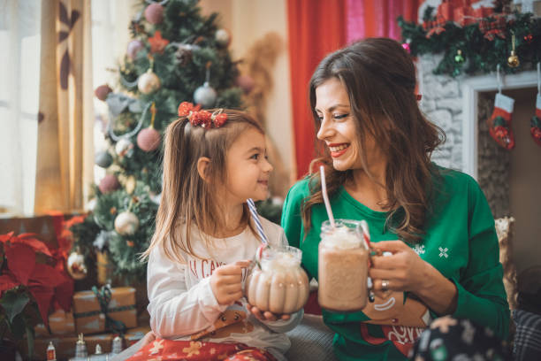 mutter und tochter trinken weihnachtsmilch und kakao während der weihnachtsferien. - 2 3 months mother child family stock-fotos und bilder