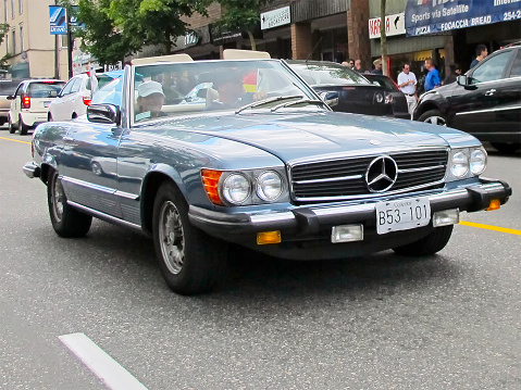 Blue colored Mercedes-Benz convertible Coupe sports car with detachable roof seen in traffic in downtown Vancouver city, Canada, Northern America