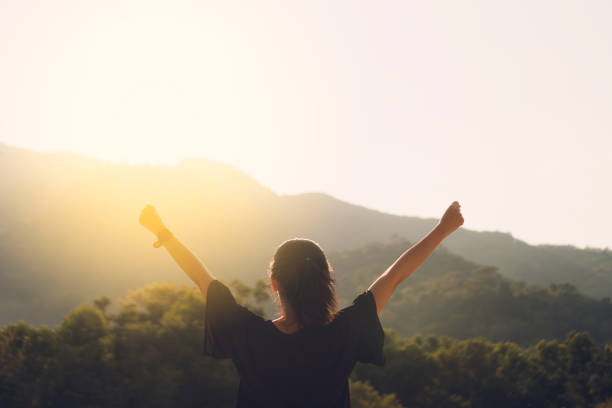 Copy space of silhouette woman raise hand up on top of mountain and sunset sky cloud abstract background. Copy space of silhouette woman raise hand up on top of mountain and sunset sky cloud abstract background. Freedom feel good and travel adventure holiday concept. Vintage tone filter effect color style hope stock pictures, royalty-free photos & images