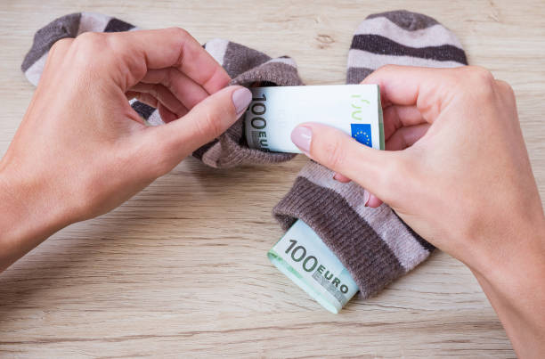 istock Female hands hide Euro banknotes in woolen socks 1275777536