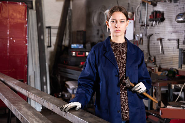 istock Young woman  mechanic working with hand hammer 1275777572
