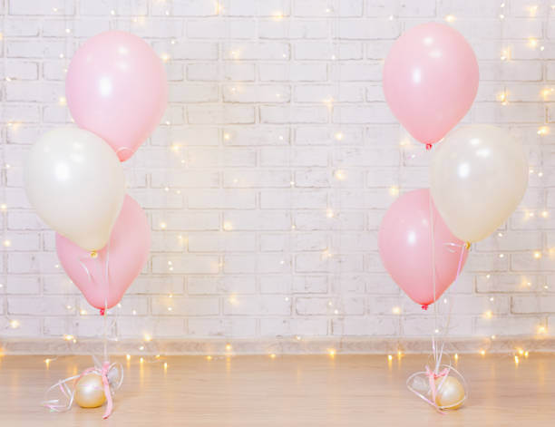 birthday party concept - brick wall background with lights and balloons stock photo