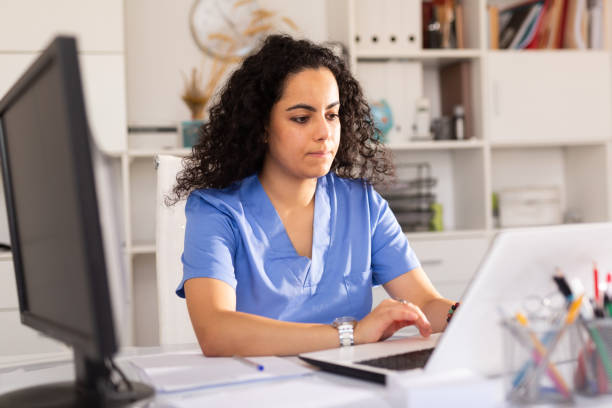 medico donna che lavora su laptop in ufficio - laptop doctor using computer nurse foto e immagini stock