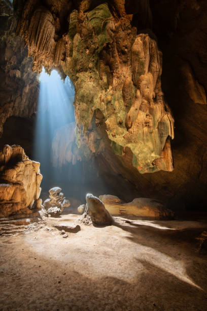 istock Sun beam with stalagmite in cave at Thailand. 1275782529