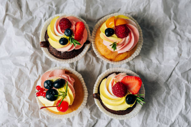 istock chocolate cupcakes with cream and fresh berries 1275784251