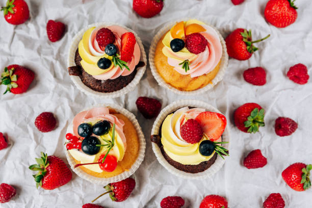 istock chocolate cupcakes with cream and fresh berries 1275785061