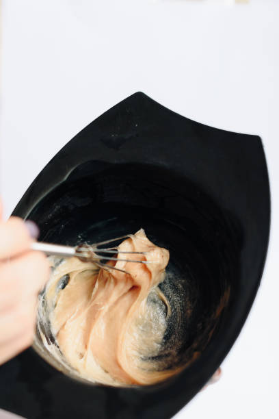 istock stylist kneads hair dye in a black container close up 1275785699