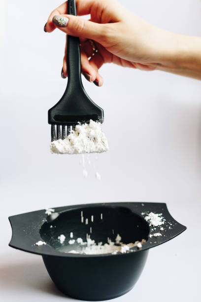 istock stylist kneads hair dye in a black container close up 1275785737