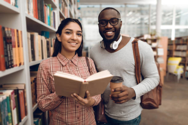 istock Ethnic mixed race girl and black guy in library. 1275788612