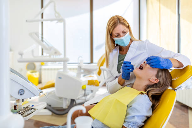 istock Female dentist checking patient girl teeth. 1275788896
