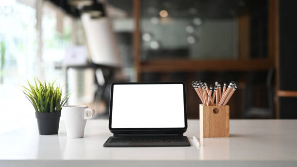 istock Tablet computer with empty screen and coffee on white office desk in modern office. 1275790826