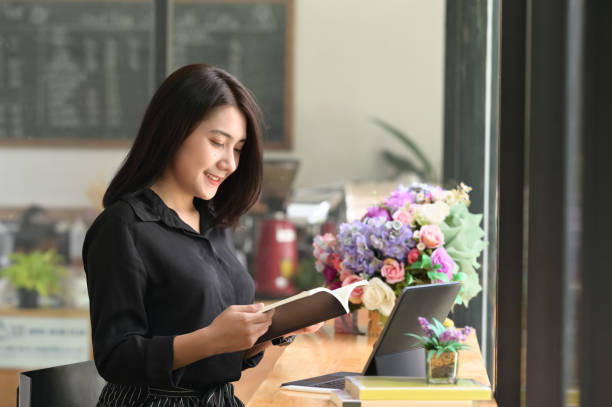 istock Young female reading her book in modern office. 1275790855