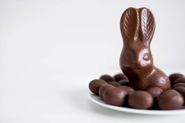 istock Easter concept - close up of chocolate bunny and eggs with copy space over white 1275792549