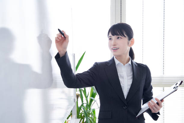 istock Japanese woman writing on a whiteboard 1275794840