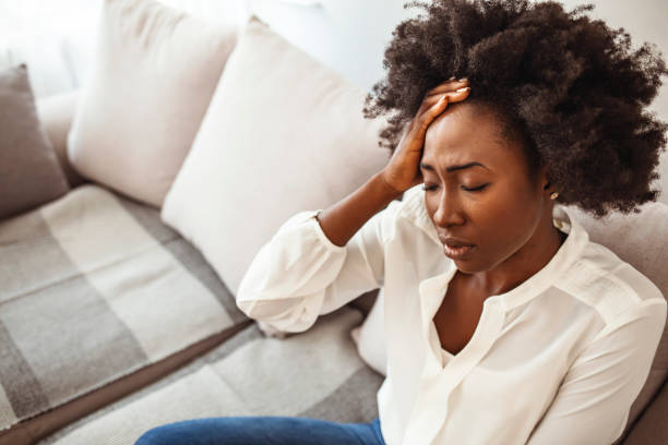 istock Young woman with headache in home interior. 1275798813