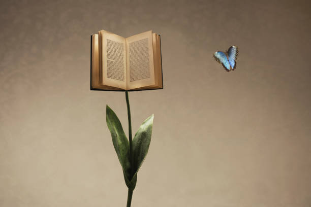 istock Surreal open book supported by a flower stem meets a colorful butterfly 1275798928