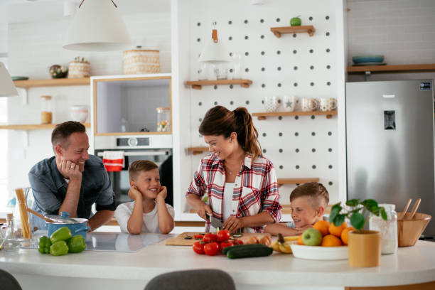 istock Mother and father making breakfast with sons. 1275800548