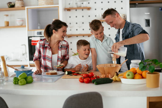 istock Mother and father making breakfast with sons. 1275800865