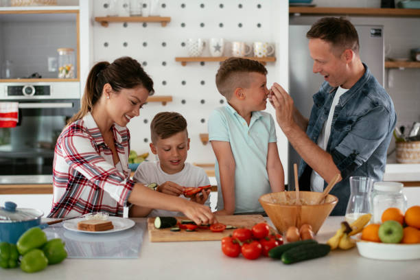 istock Mother and father making breakfast with sons. 1275800868