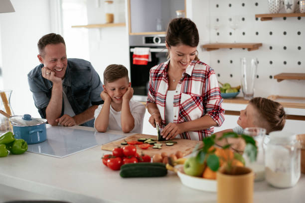 istock Mother and father making breakfast with sons. 1275801520