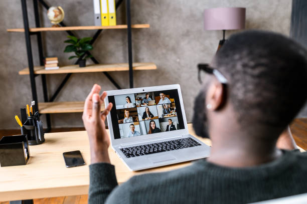 een kerel die online met werknemers via videovraag spreekt - afgelegen stockfoto's en -beelden