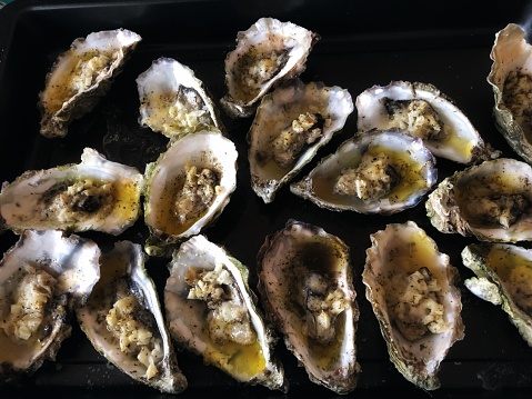 Landscape photograph of chargrilled oysters on the half shell